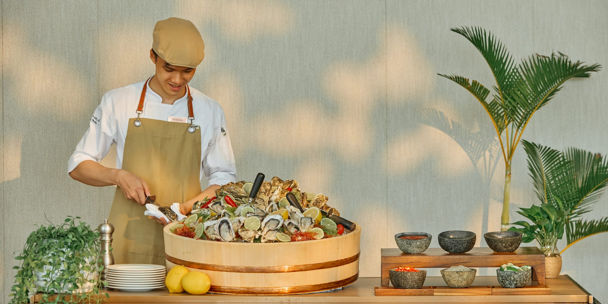 a man in an apron and hat standing next to a large tub of food