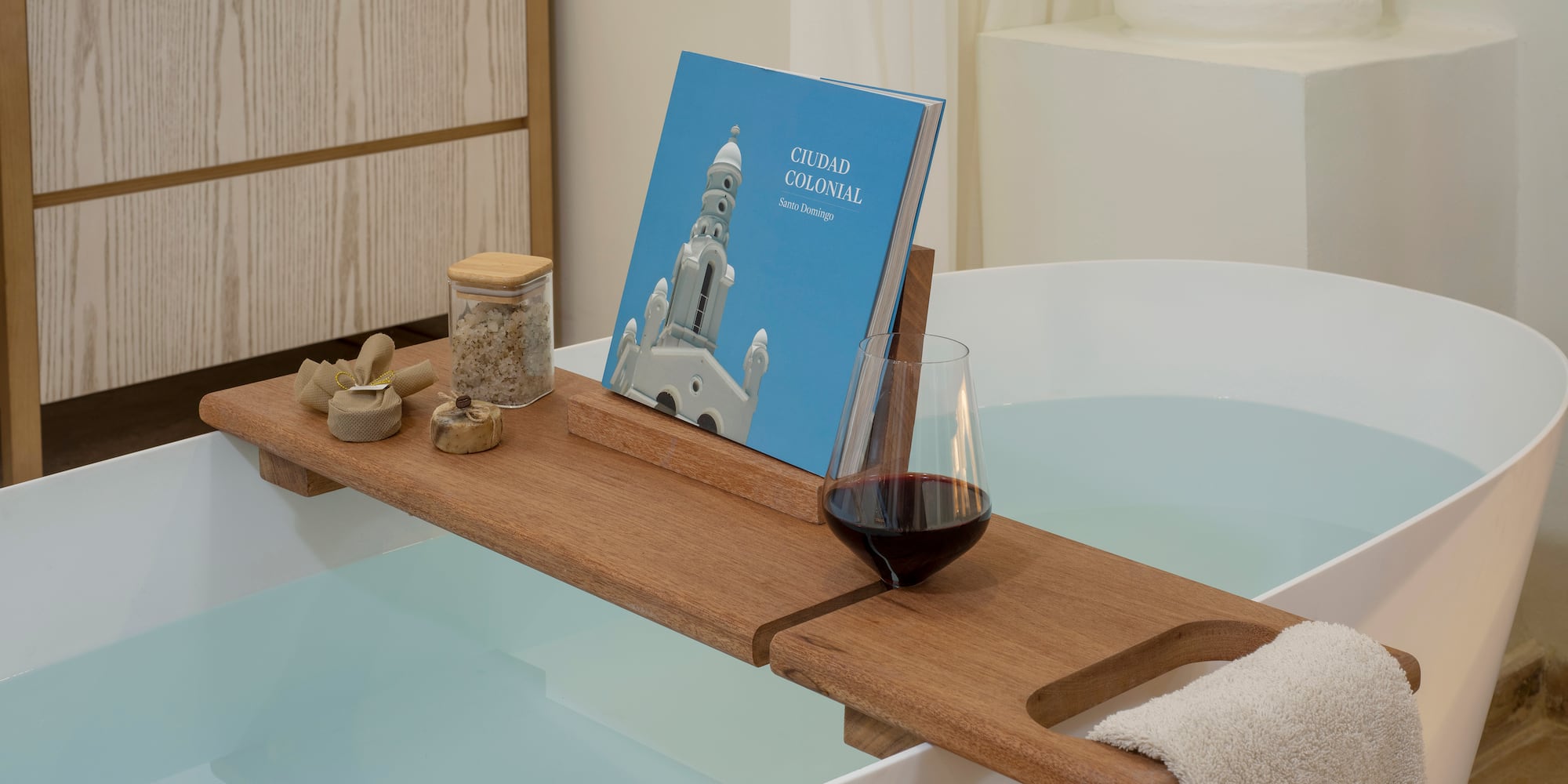 a bathtub with a book and a glass of wine