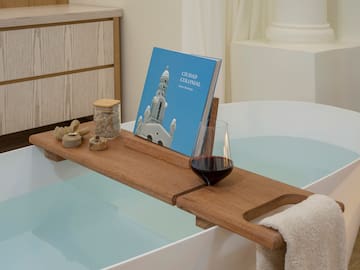 a bathtub with a book and a glass of wine