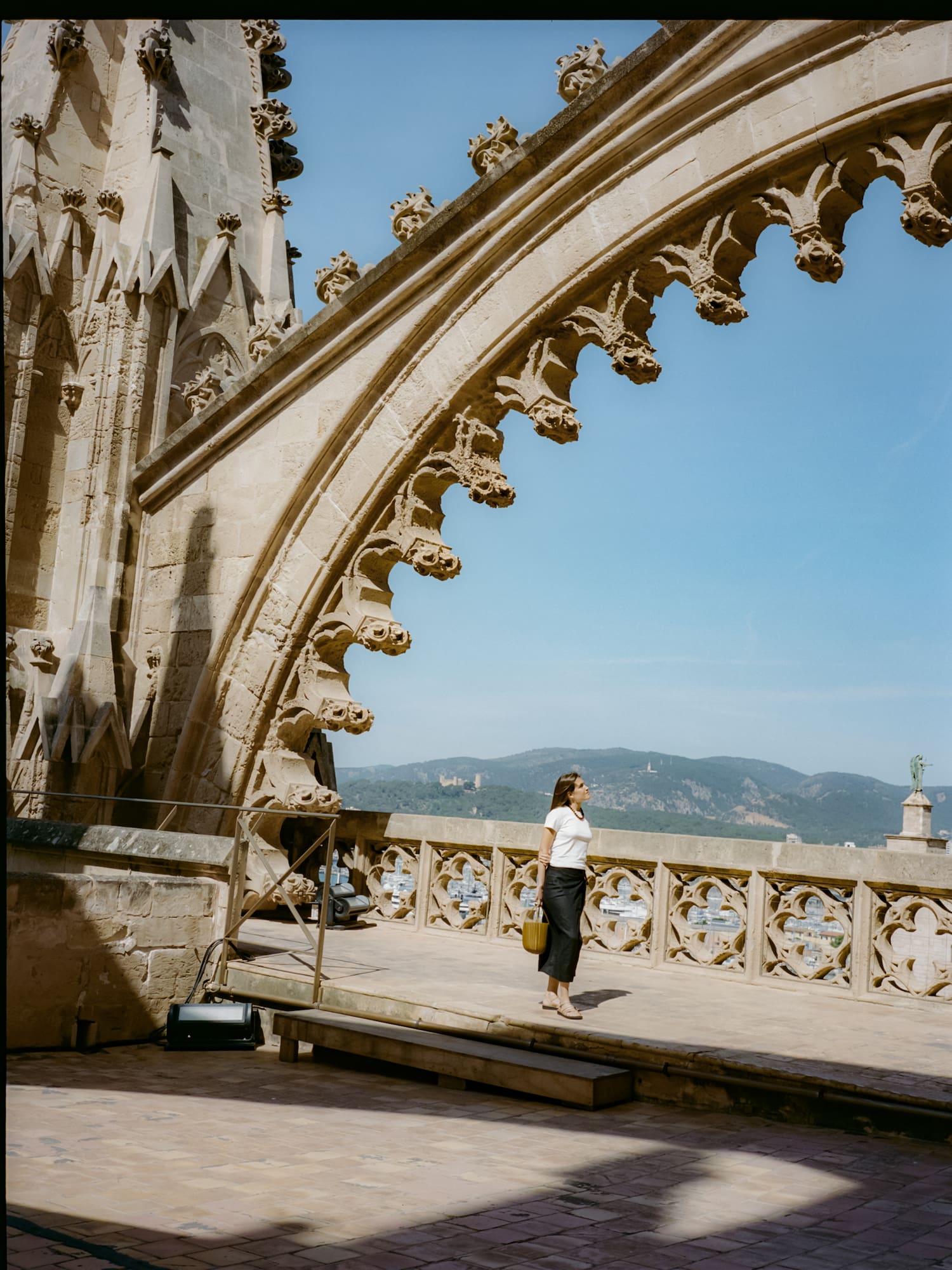a woman standing on a balcony with a large stone arch