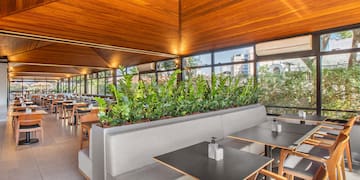 a room with tables and chairs and plants