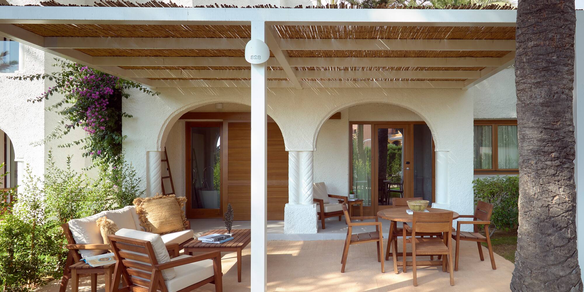 a patio with a covered patio and chairs