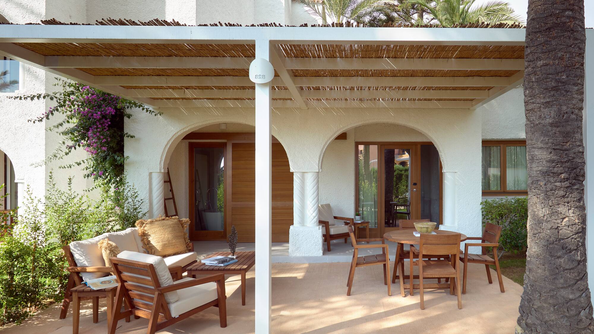 a patio with a covered patio and chairs