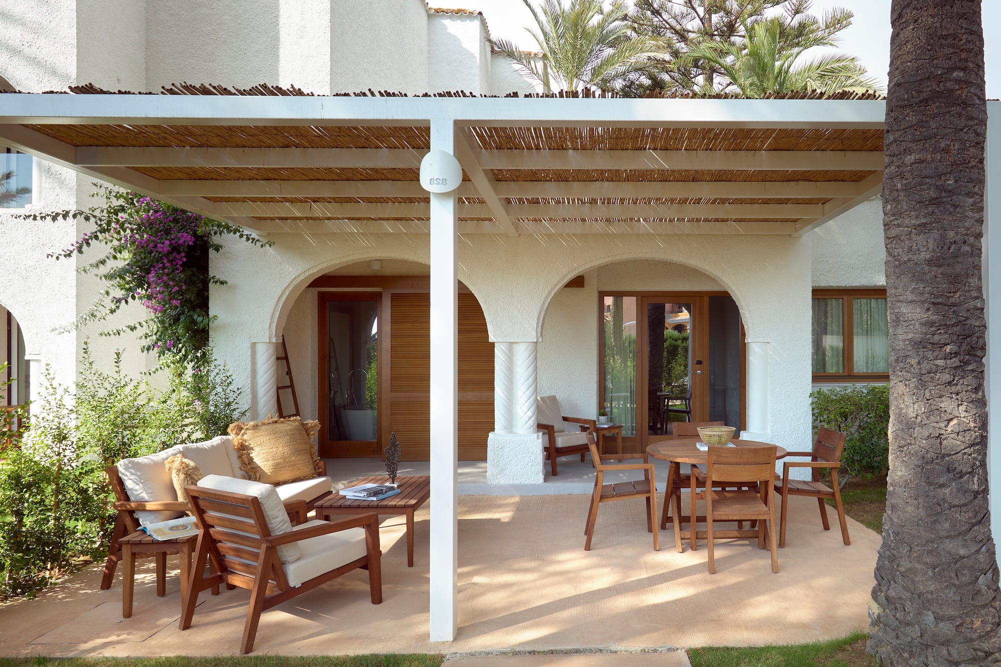 a patio with a covered patio and chairs
