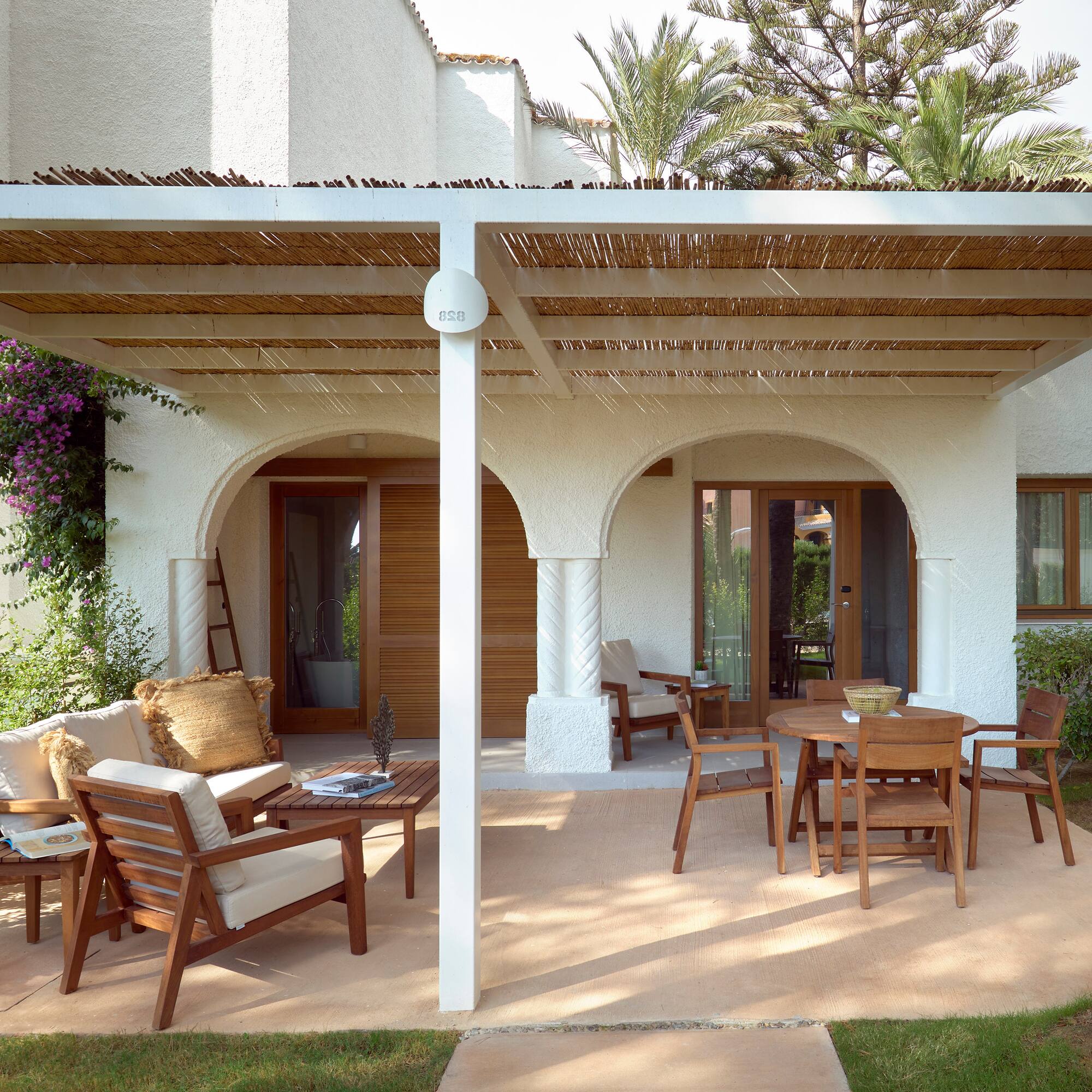a patio with a covered patio and chairs