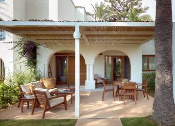 a patio with a covered patio and chairs
