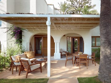 a patio with a covered patio and chairs