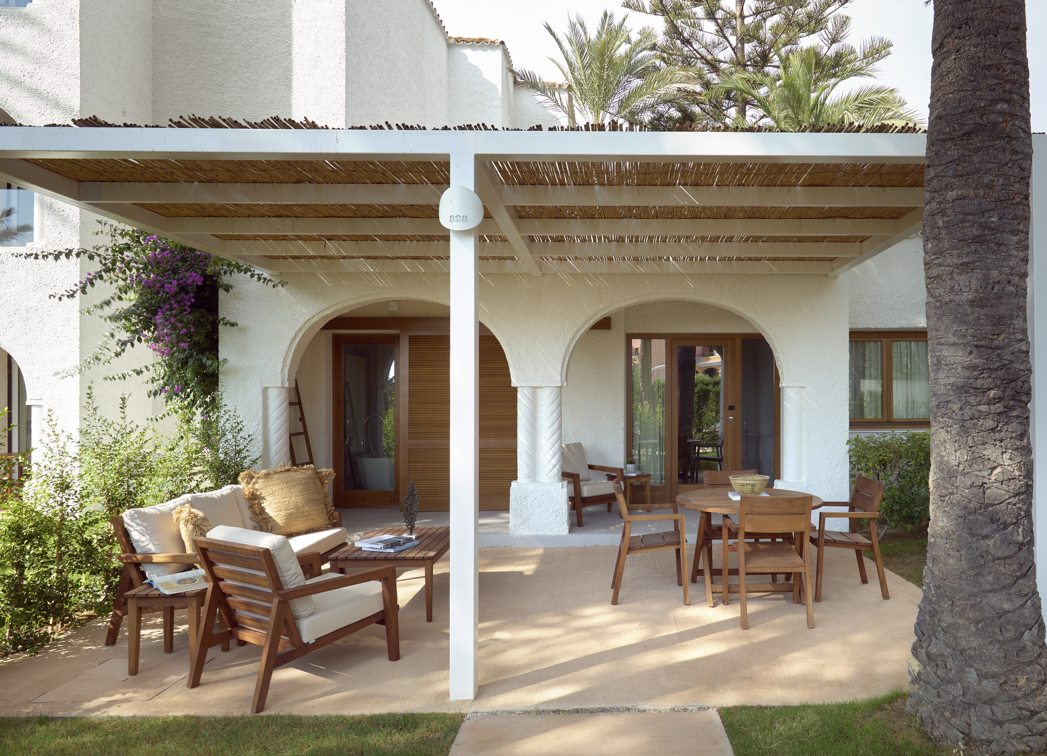a patio with a covered patio and chairs