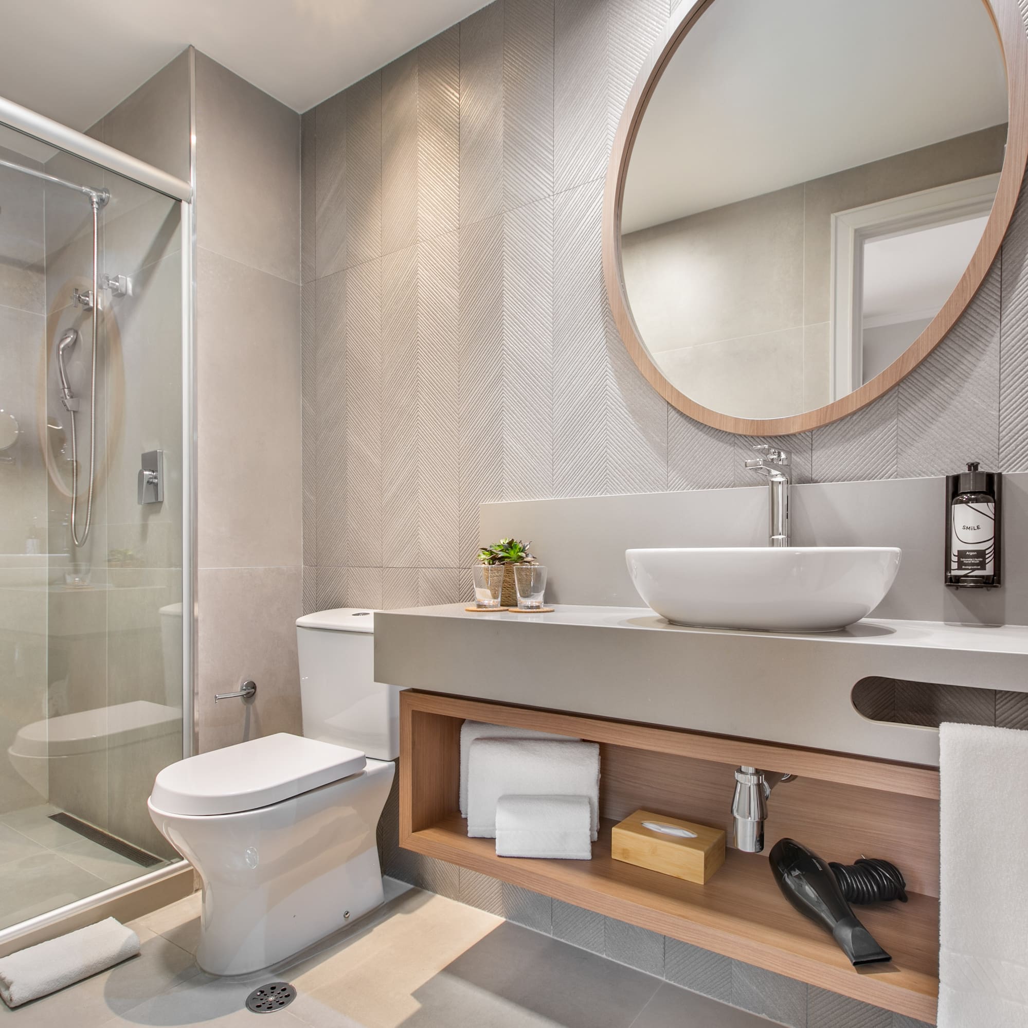 a bathroom with a round mirror and a sink