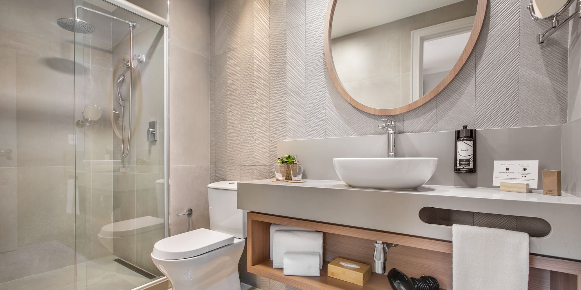 a bathroom with a round mirror and a sink