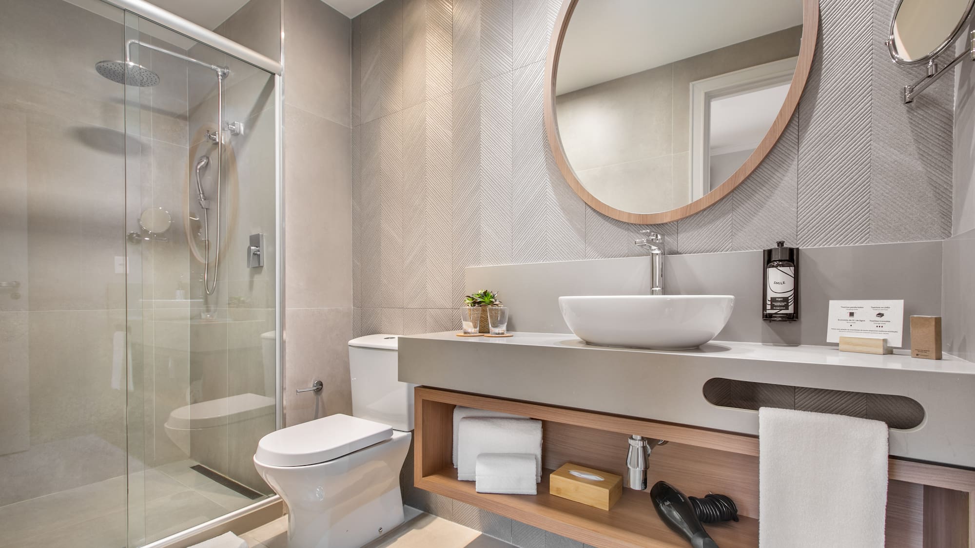 a bathroom with a round mirror and a sink