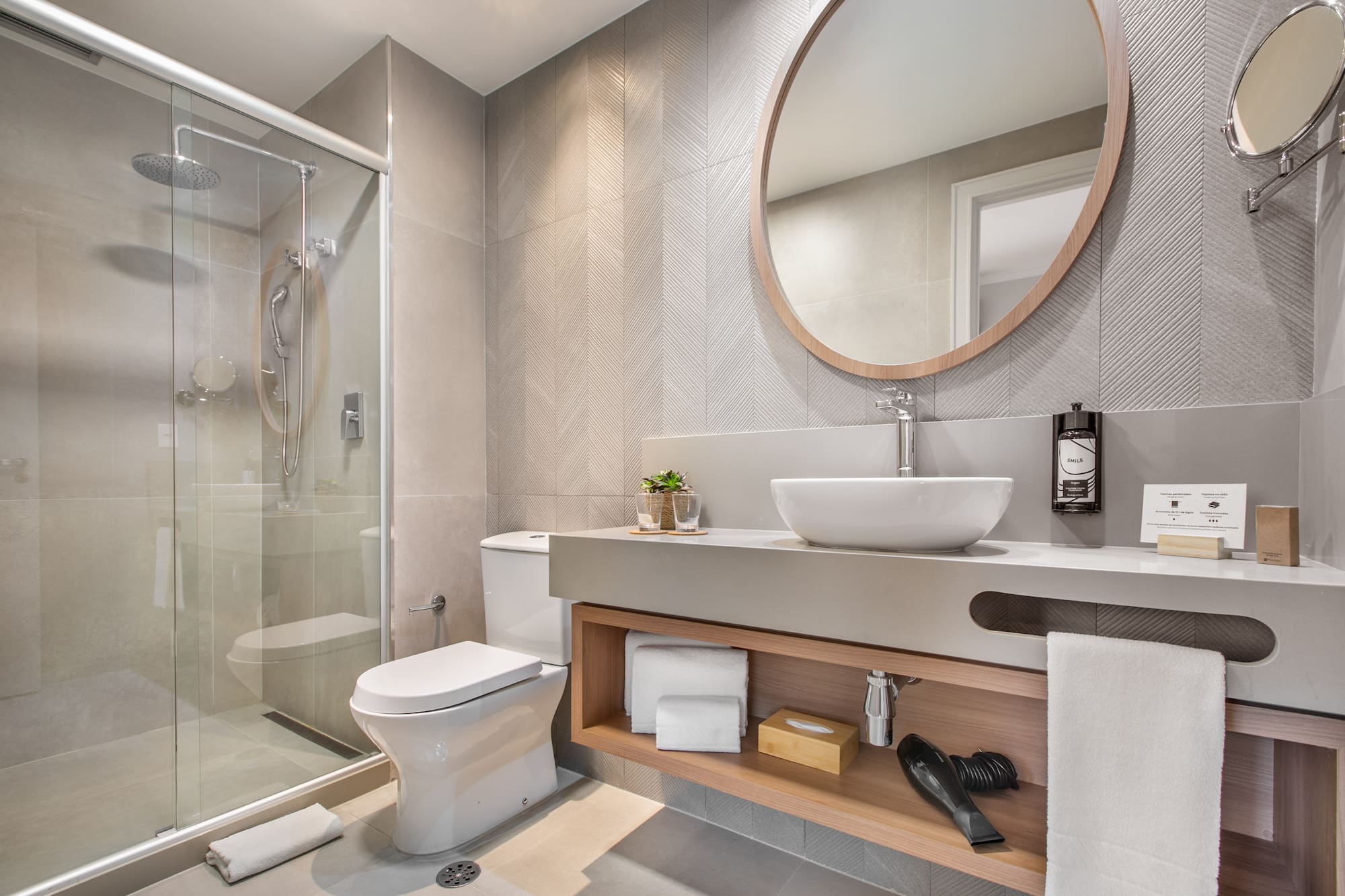 a bathroom with a round mirror and a sink