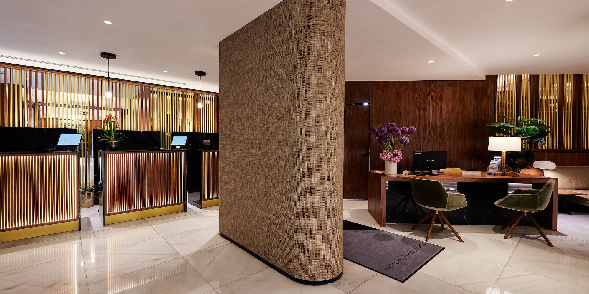 a room with a large column and a desk and computer