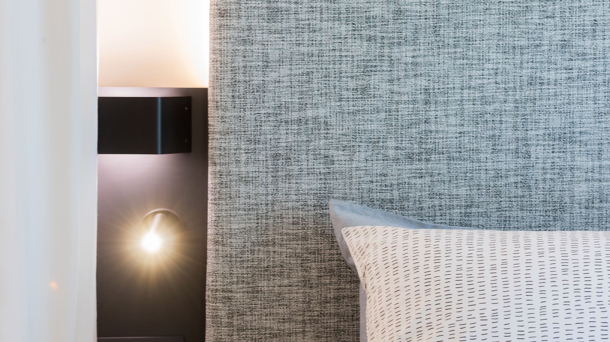 a coffee cup on a table next to a bed