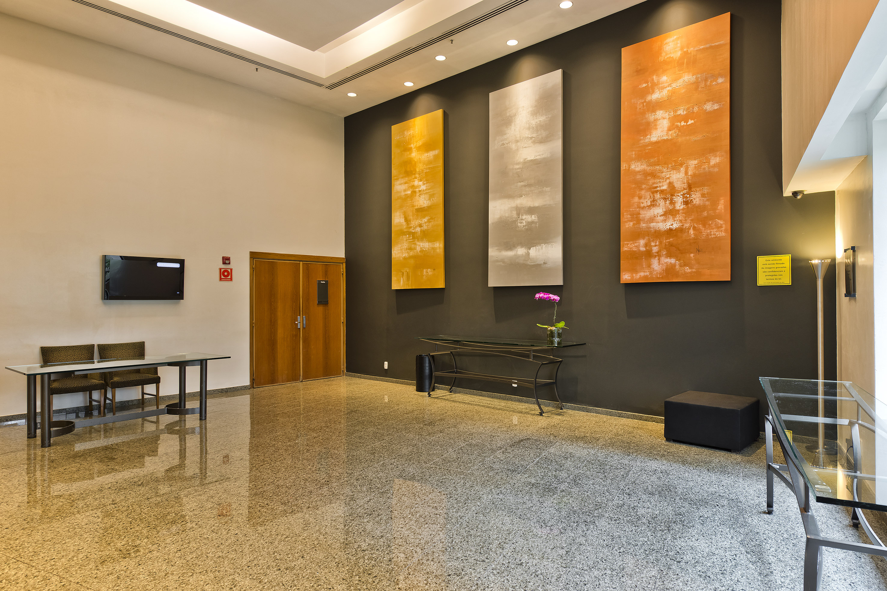 Modern hotel lobby with abstract art, polished granite floor, and seating.