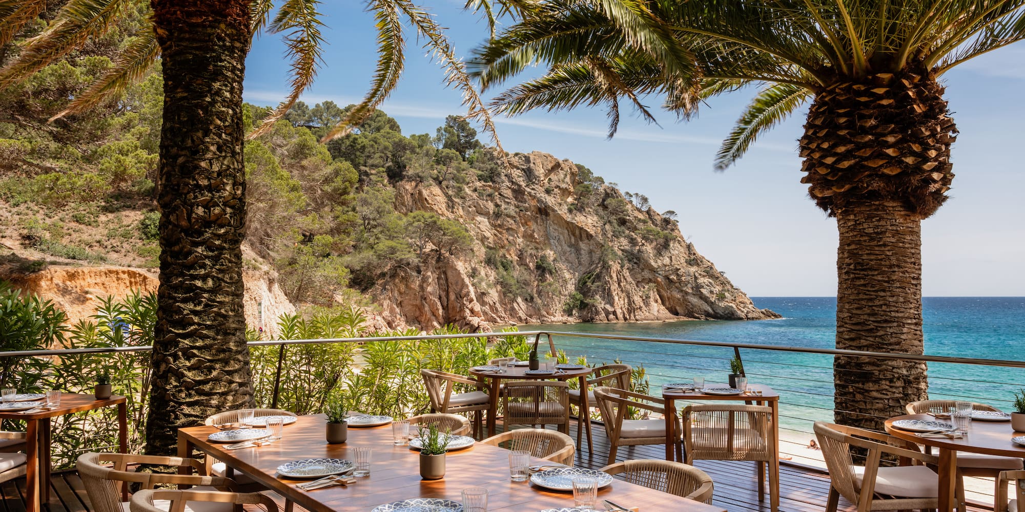 a table and chairs on a deck overlooking a body of water