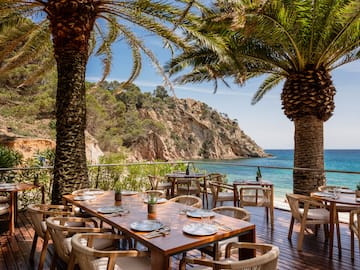 a table and chairs on a deck overlooking a body of water