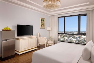 a bedroom with a large television and a large window