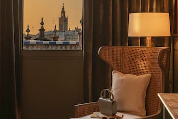 a chair with a pillow and a lamp in front of a window
