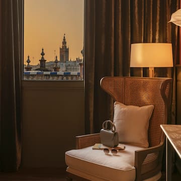 a chair with a pillow and a lamp in front of a window