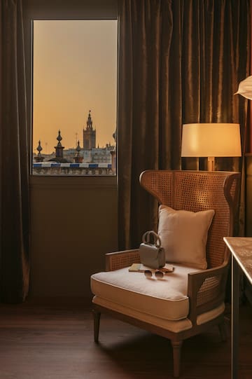a chair with a pillow and a lamp in front of a window