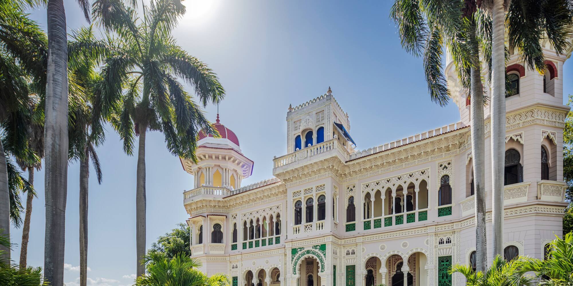a large white building with palm trees