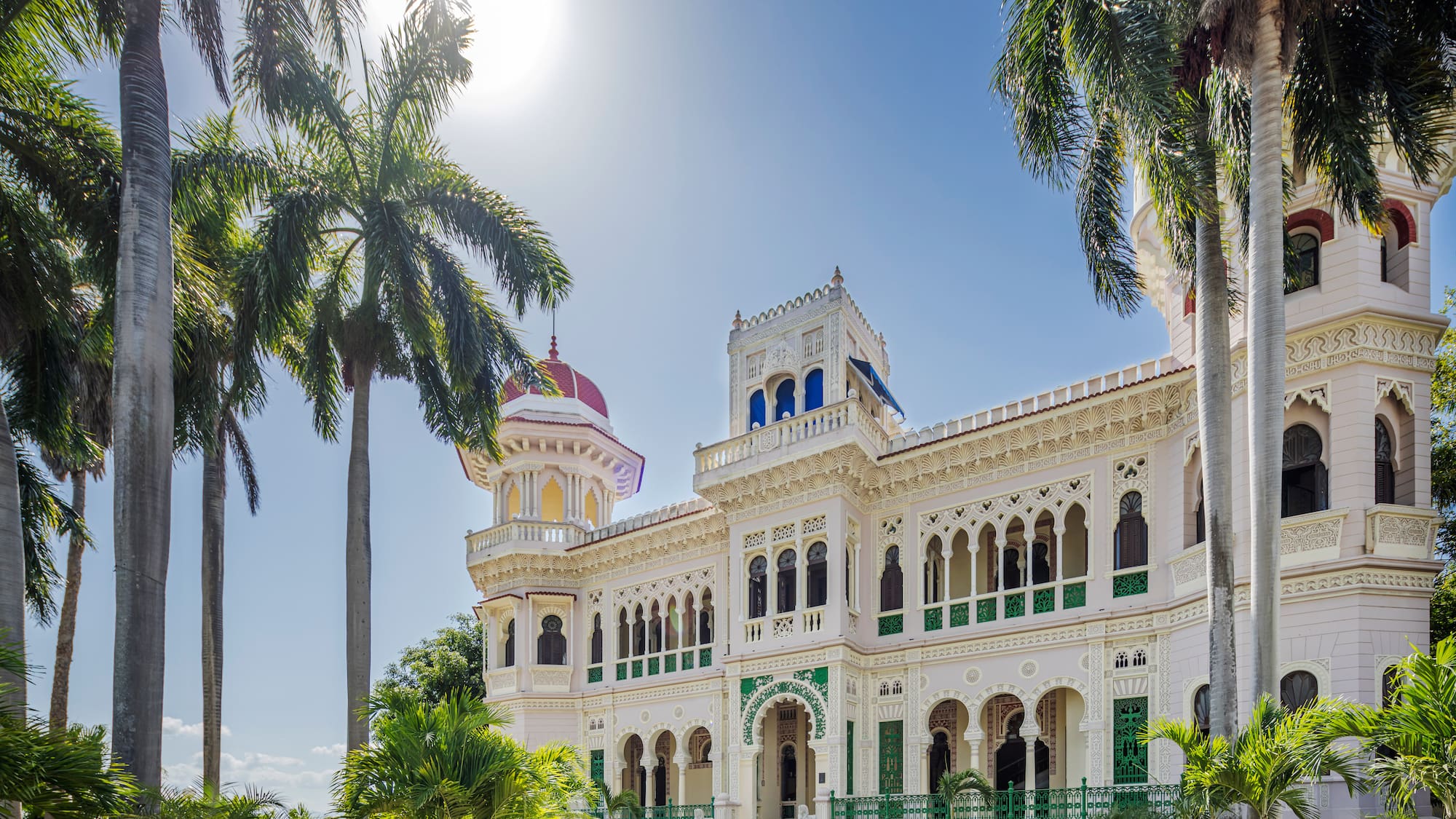 a large white building with palm trees