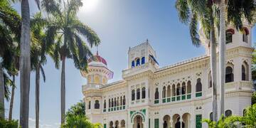 a large white building with palm trees