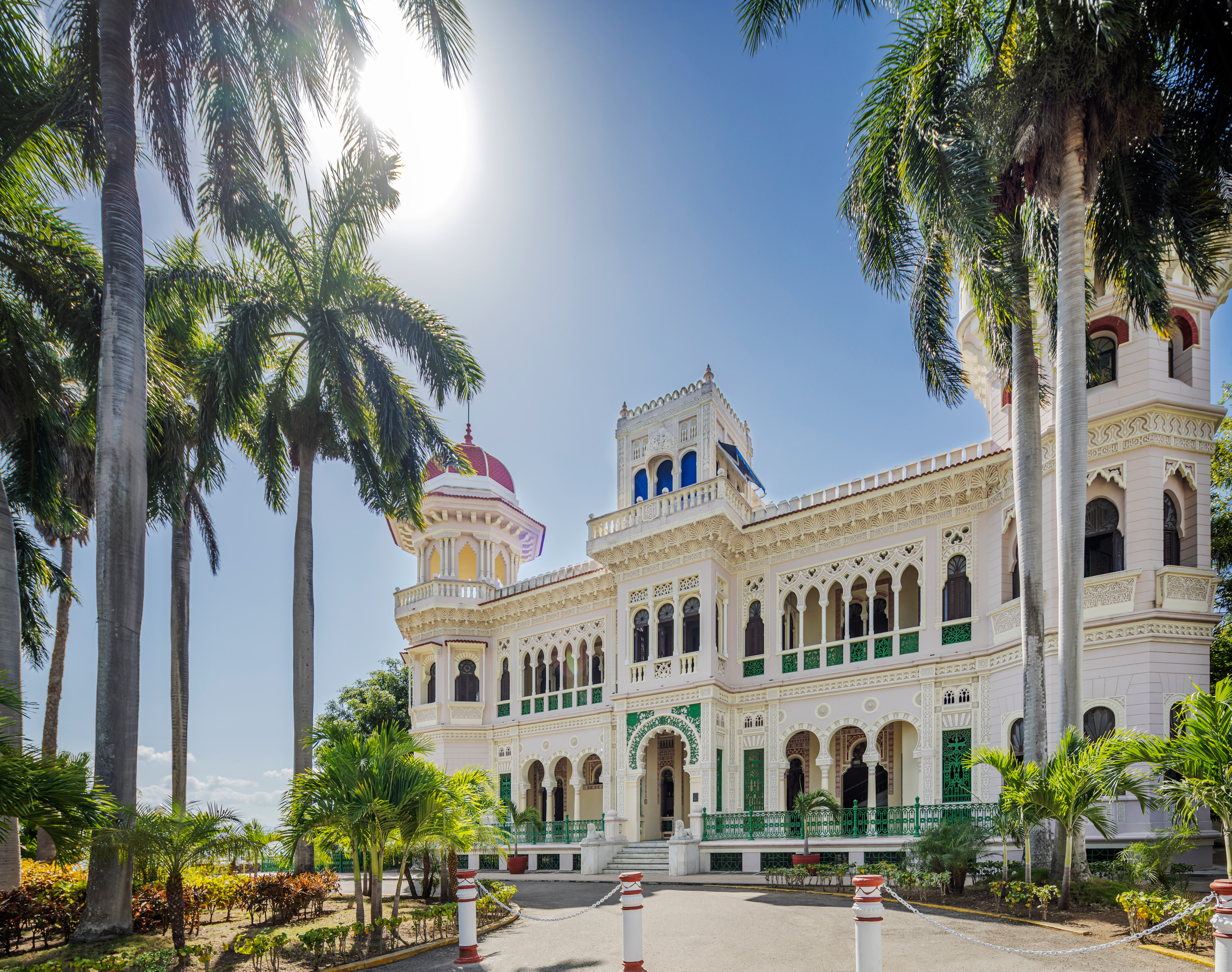 a large white building with palm trees
