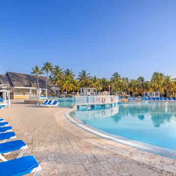a pool with lounge chairs and palm trees