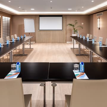 a room with a large screen and tables