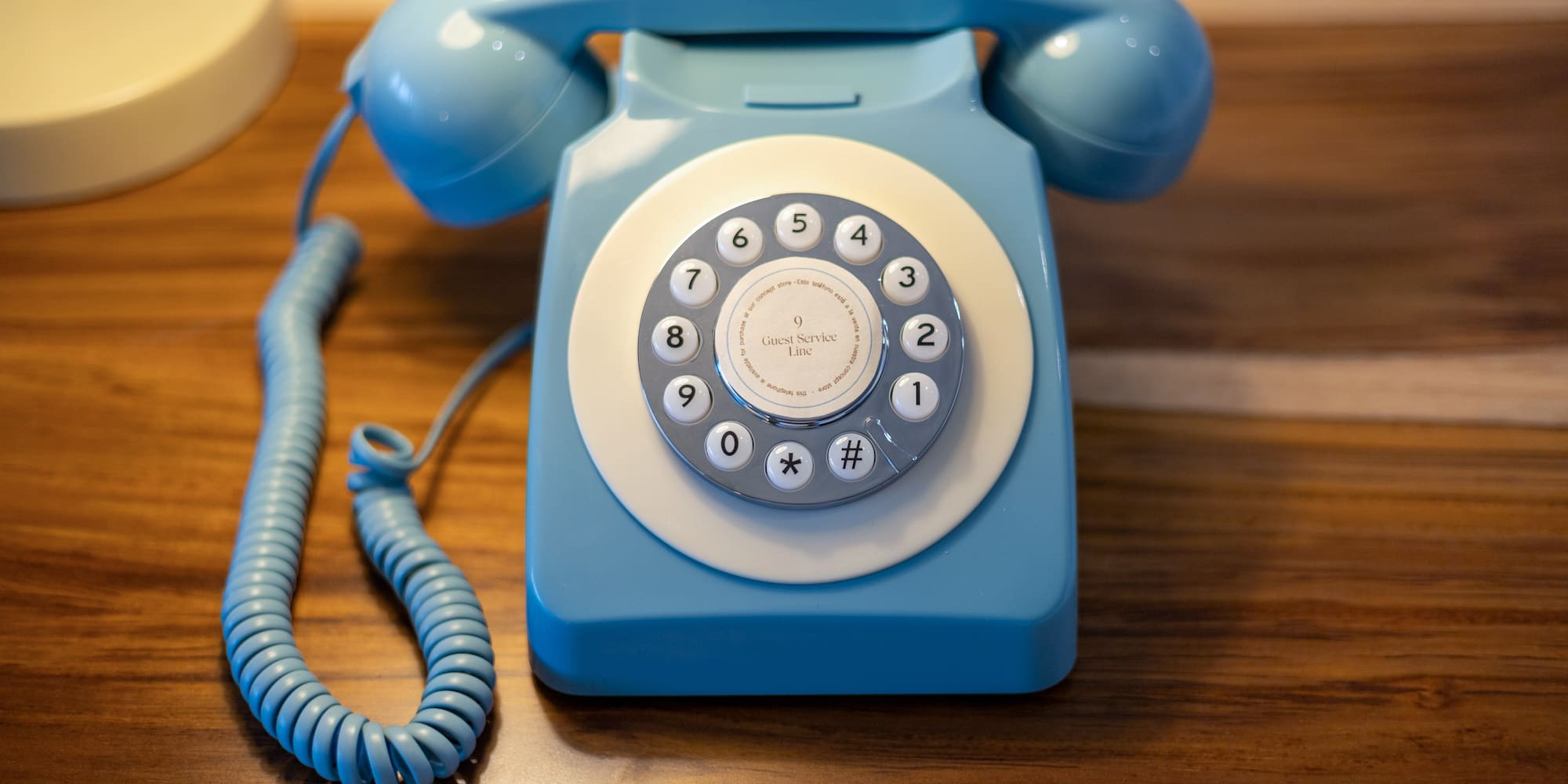Teléfono azul retro para servicio de habitaciones con marcación rotatoria.