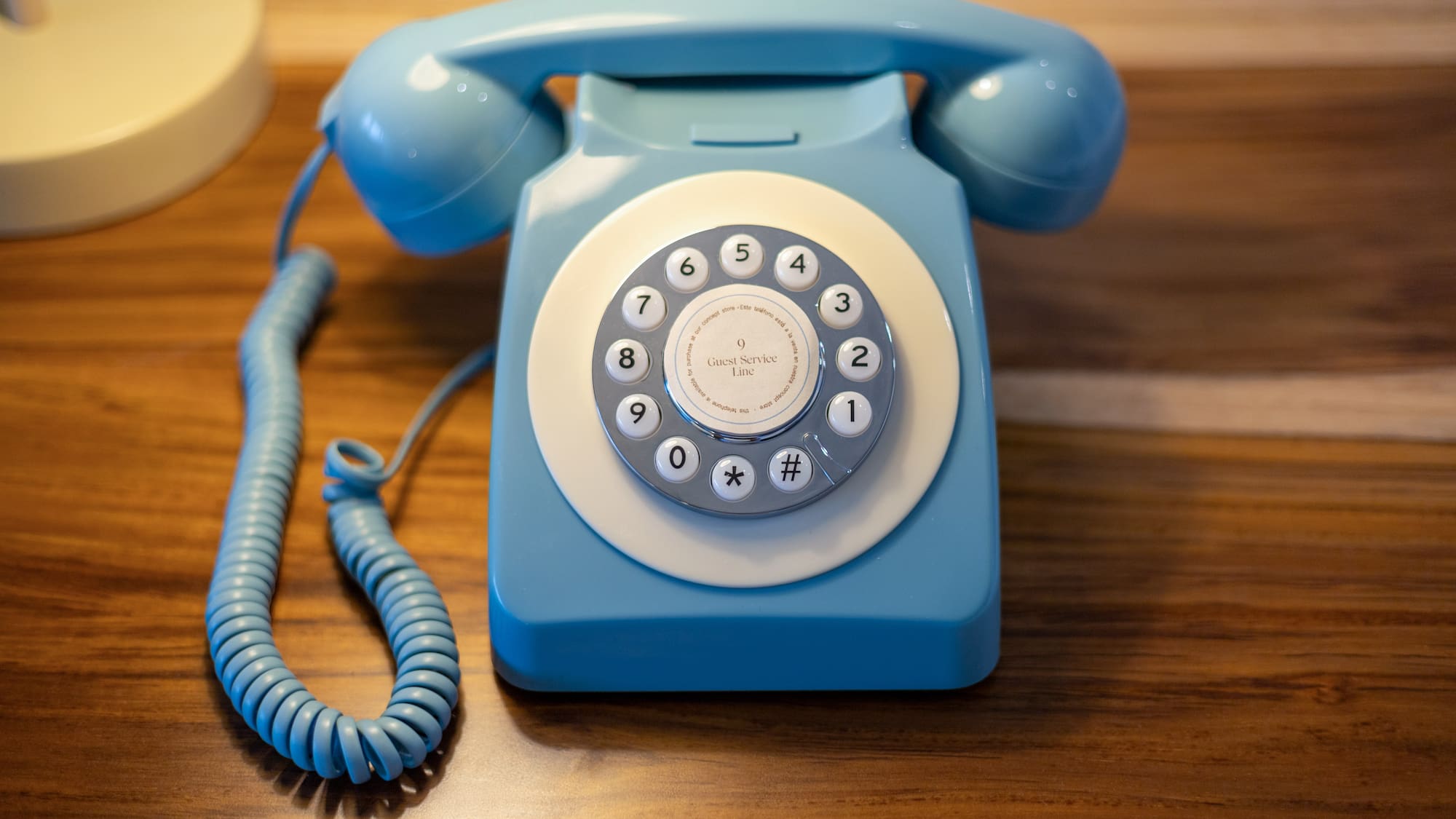 Teléfono azul retro para servicio de habitaciones con marcación rotatoria.