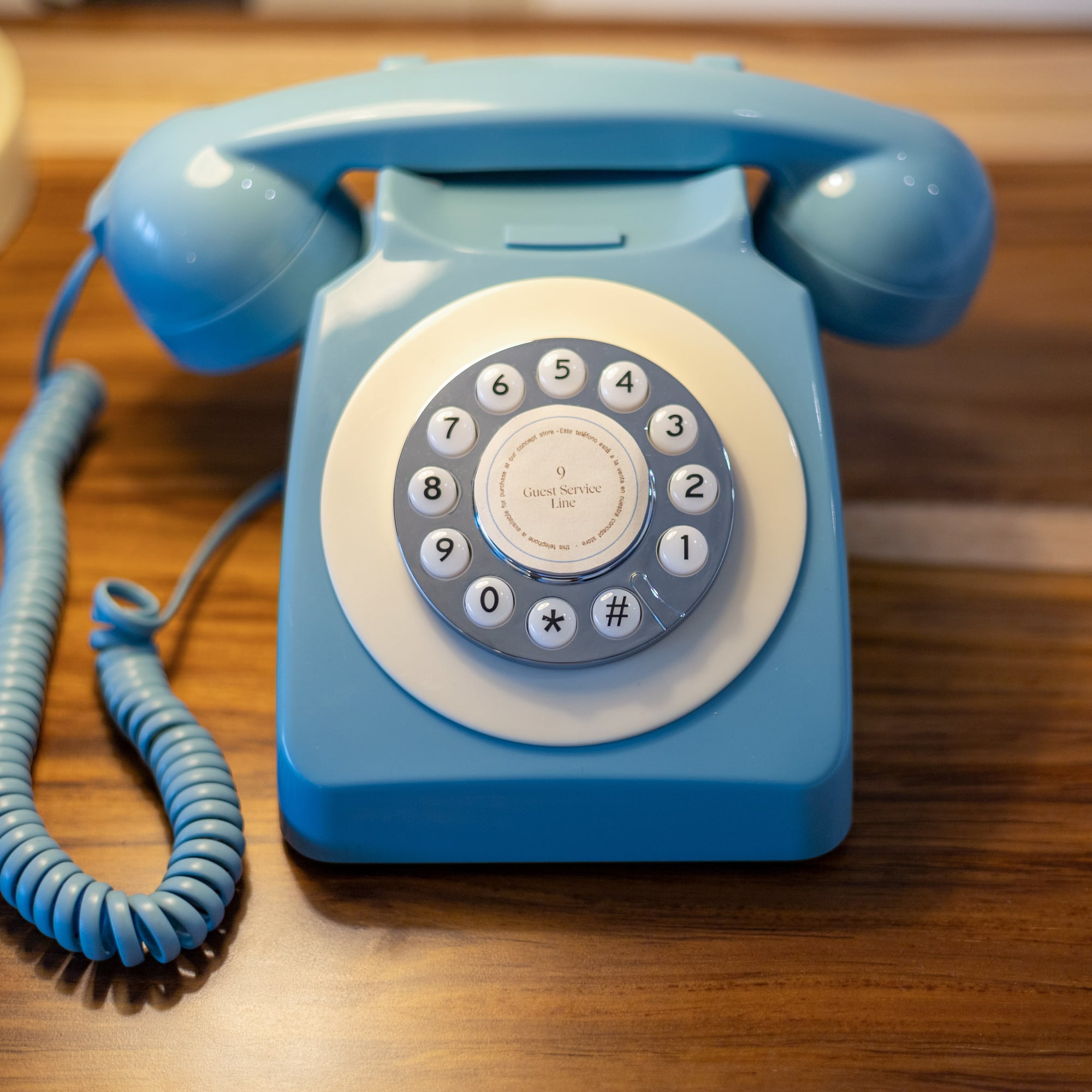 Teléfono azul retro para servicio de habitaciones con marcación rotatoria.