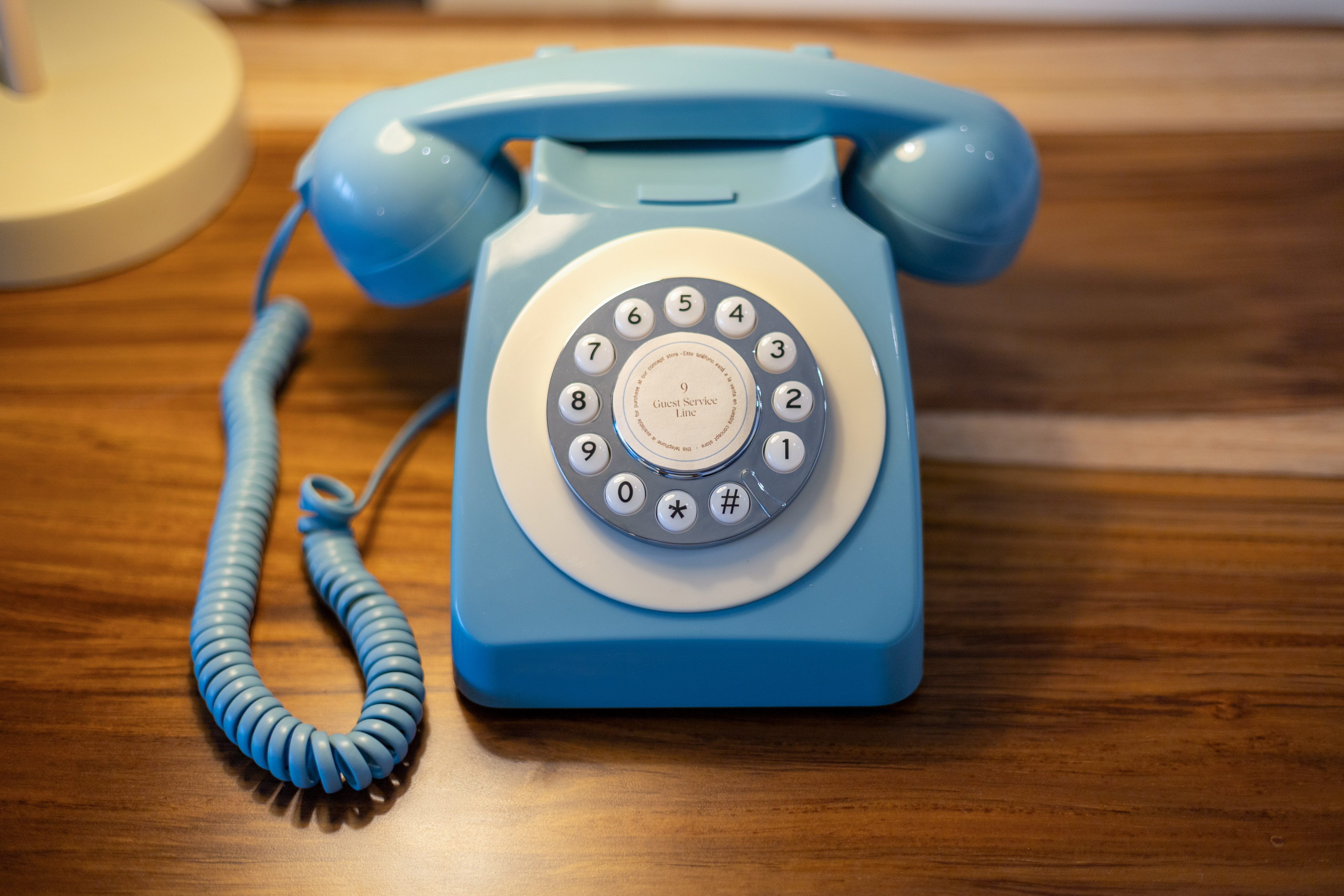 Teléfono azul retro para servicio de habitaciones con marcación rotatoria.