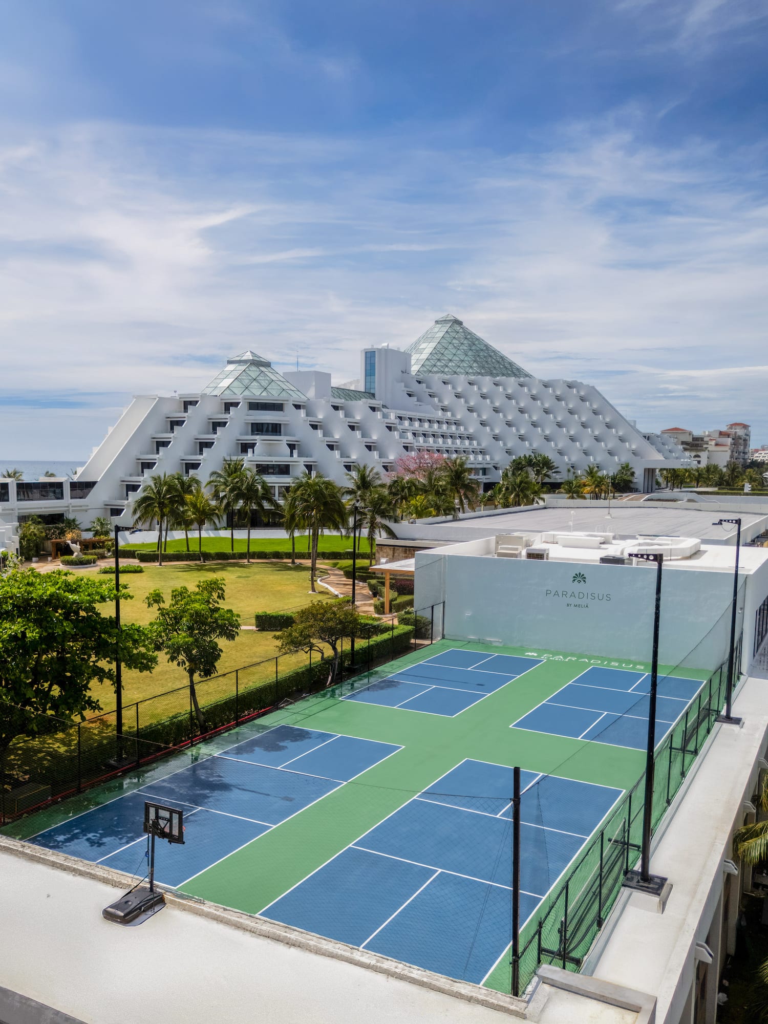 Hotel Paradisus Meliá, canchas azules y verdes, jardín, palmeras y mar.