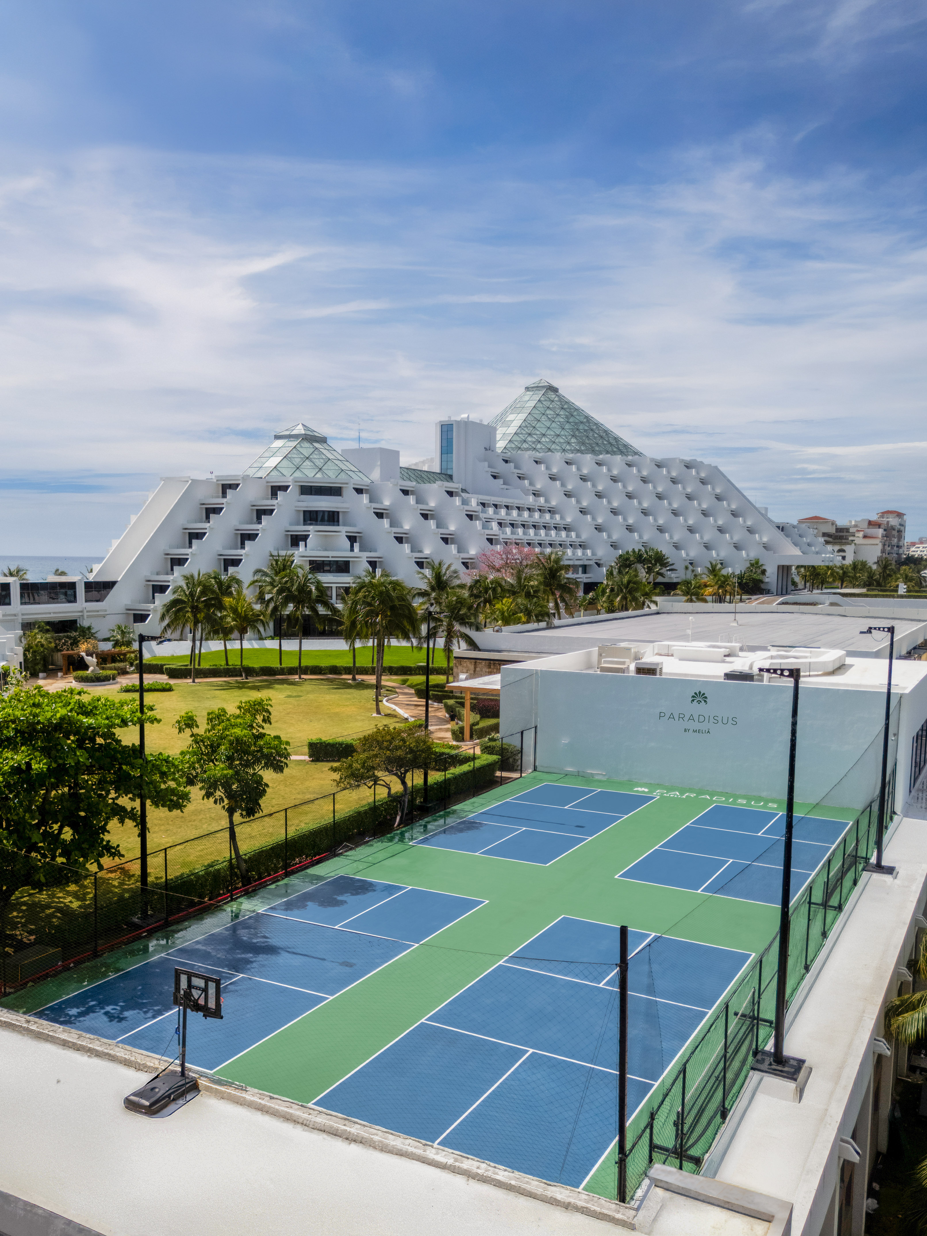 Hotel Paradisus Meliá, canchas azules y verdes, jardín, palmeras y mar.