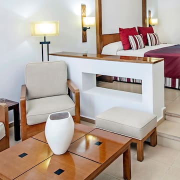 a room with a bed and chairs