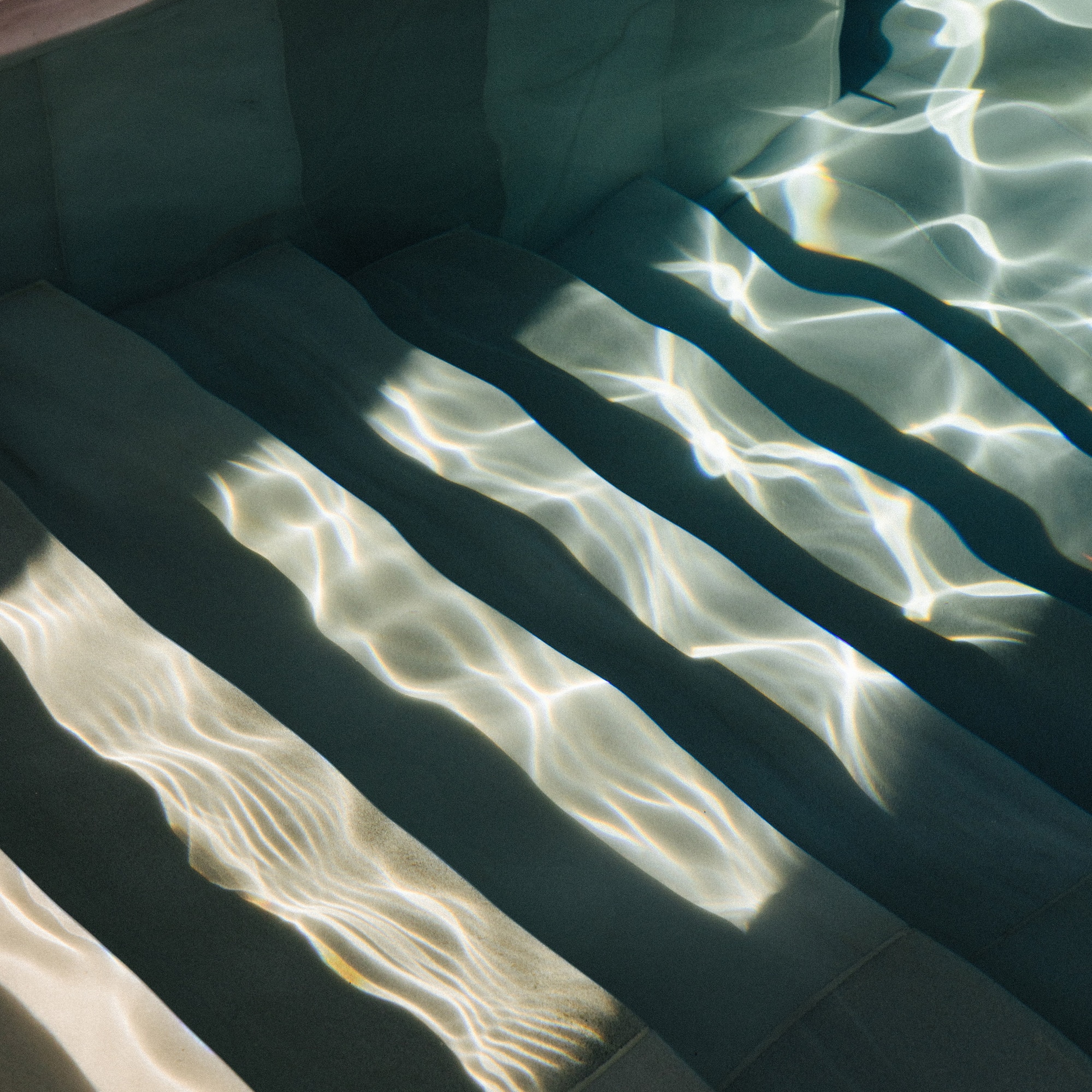 a stairs under water with sunlight shining on them