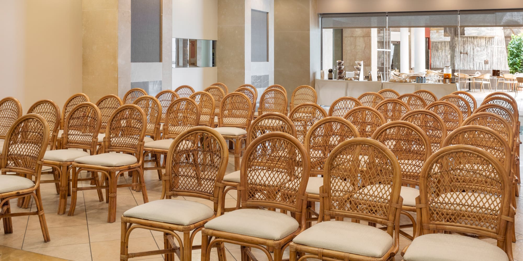 Rows of woven rattan chairs in a modern hotel conference room.
