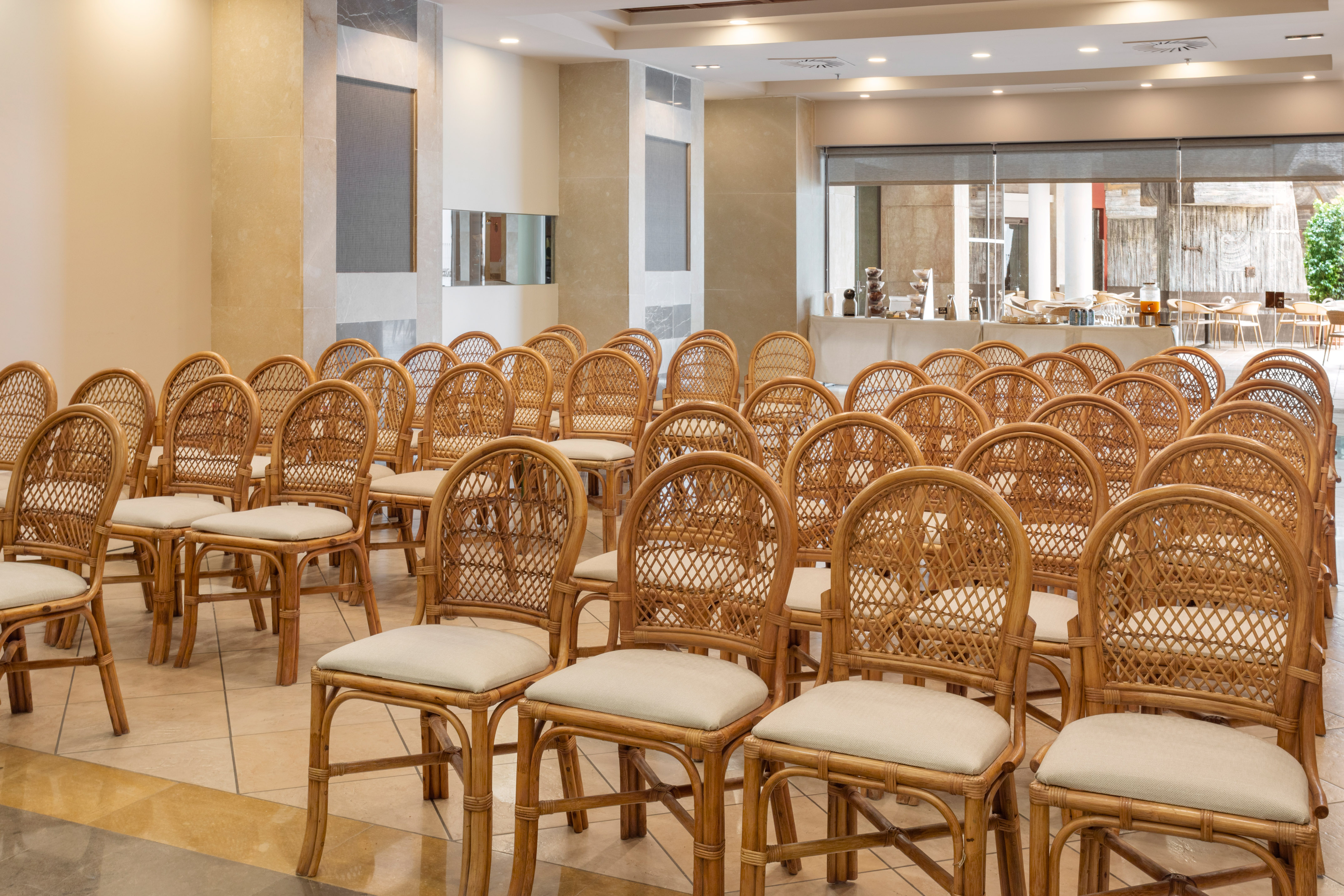 Rows of woven rattan chairs in a modern hotel conference room.