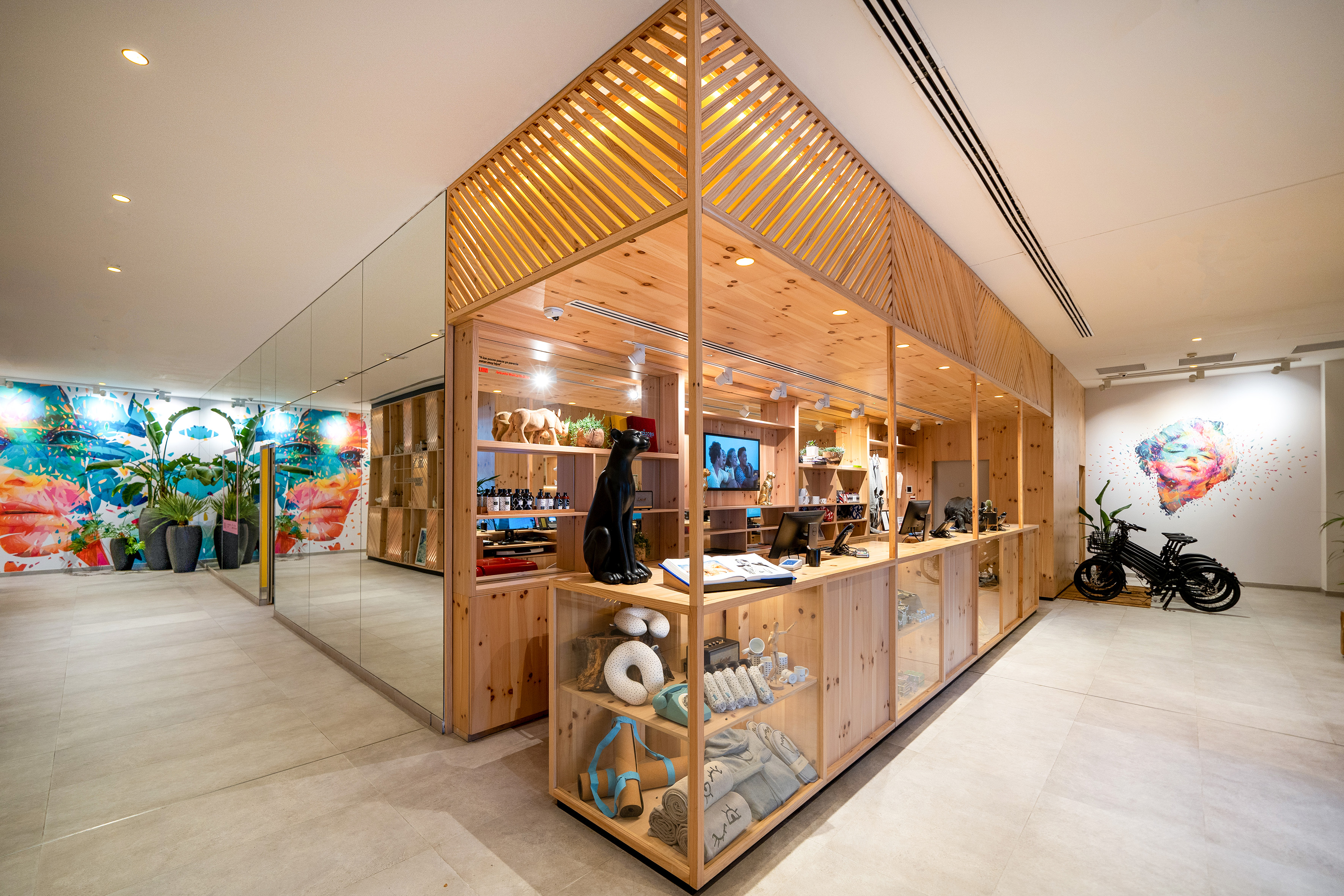 Modern retail store featuring wooden display, lifestyle products, colorful art.