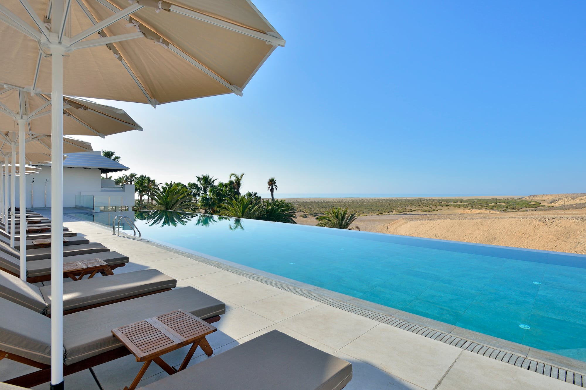 a pool with lounge chairs and umbrellas