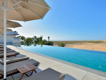 a pool with lounge chairs and umbrellas