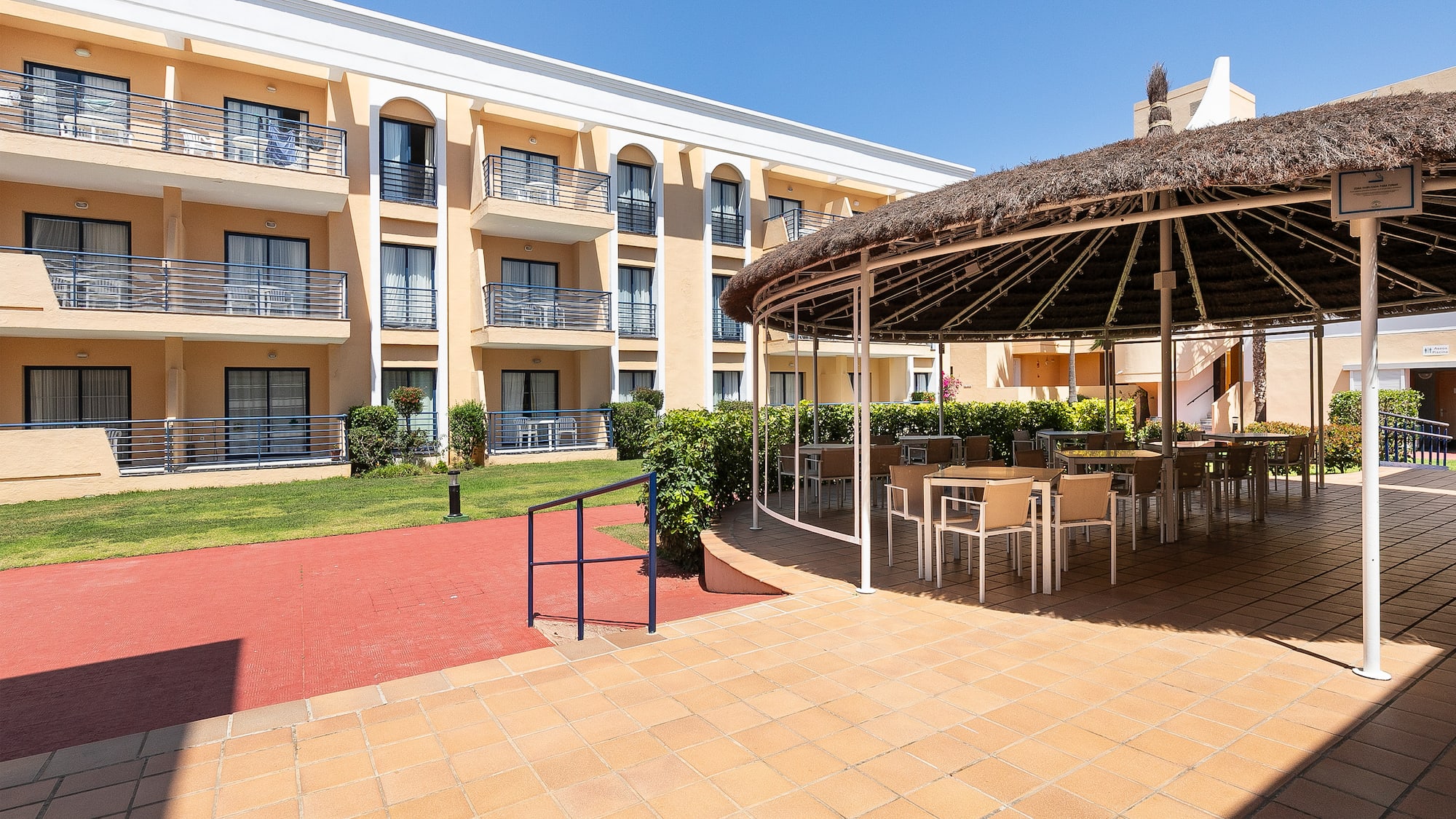 a patio with a thatched roof and chairs
