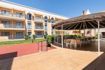 a patio with a thatched roof and chairs