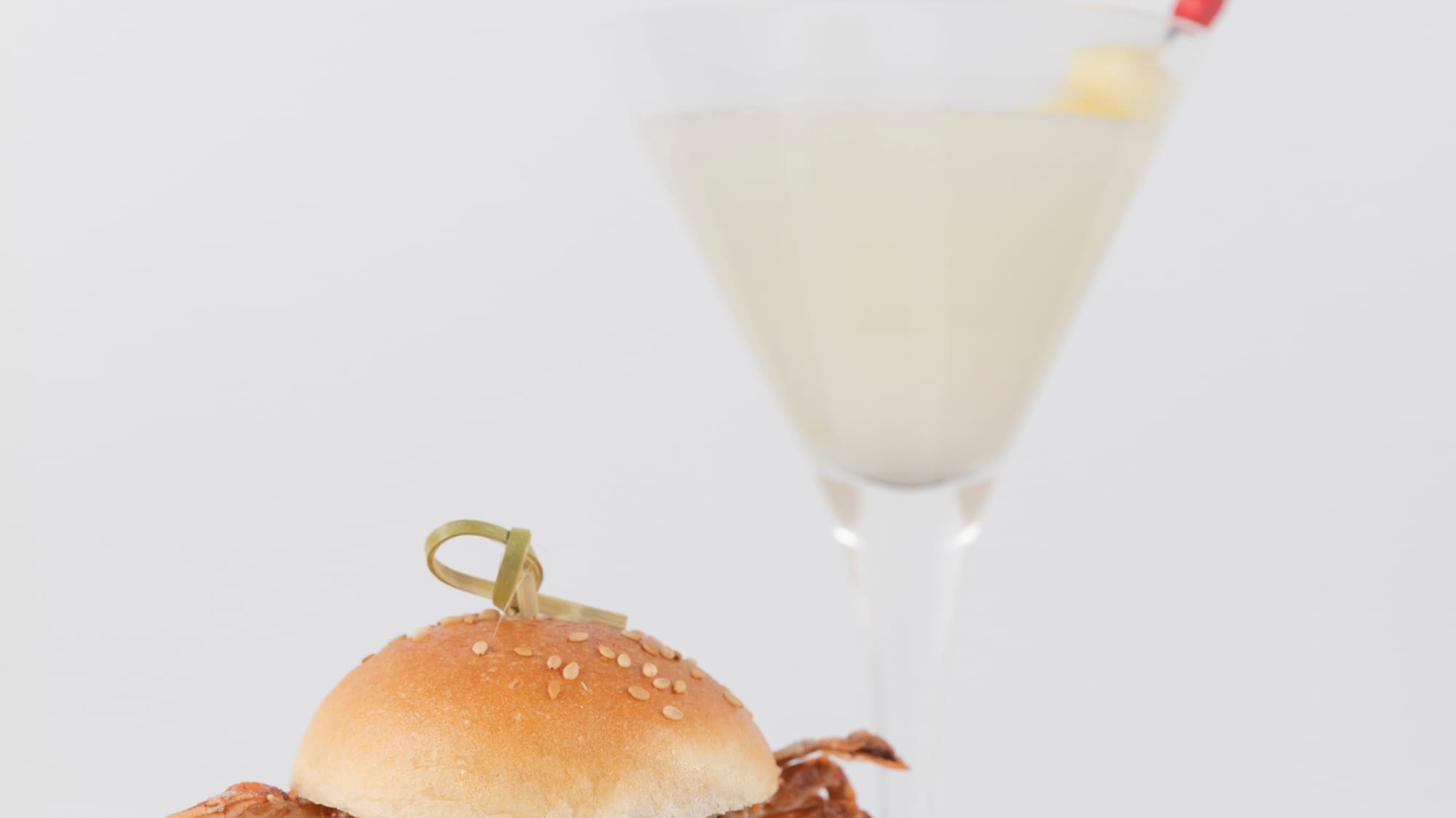 a crab sandwich on a plate next to a glass of liquid