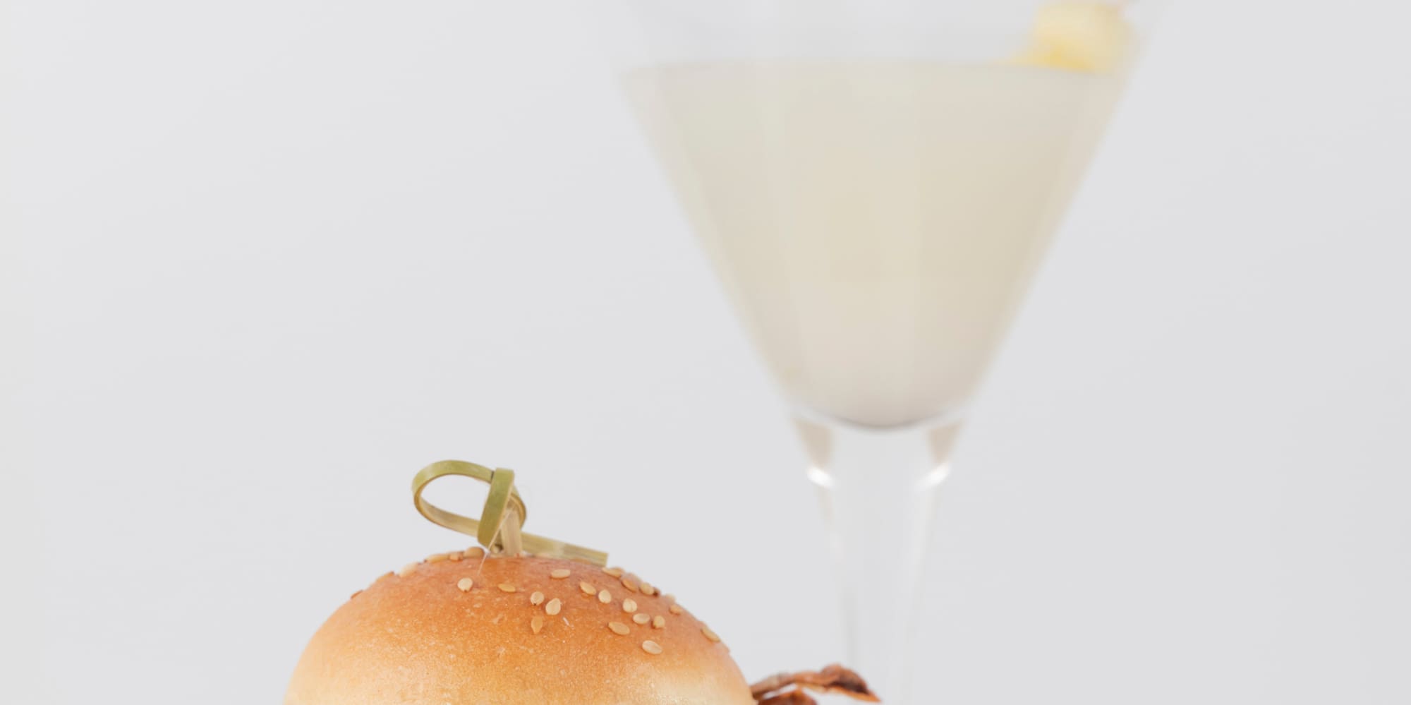 a crab sandwich on a plate next to a glass of liquid
