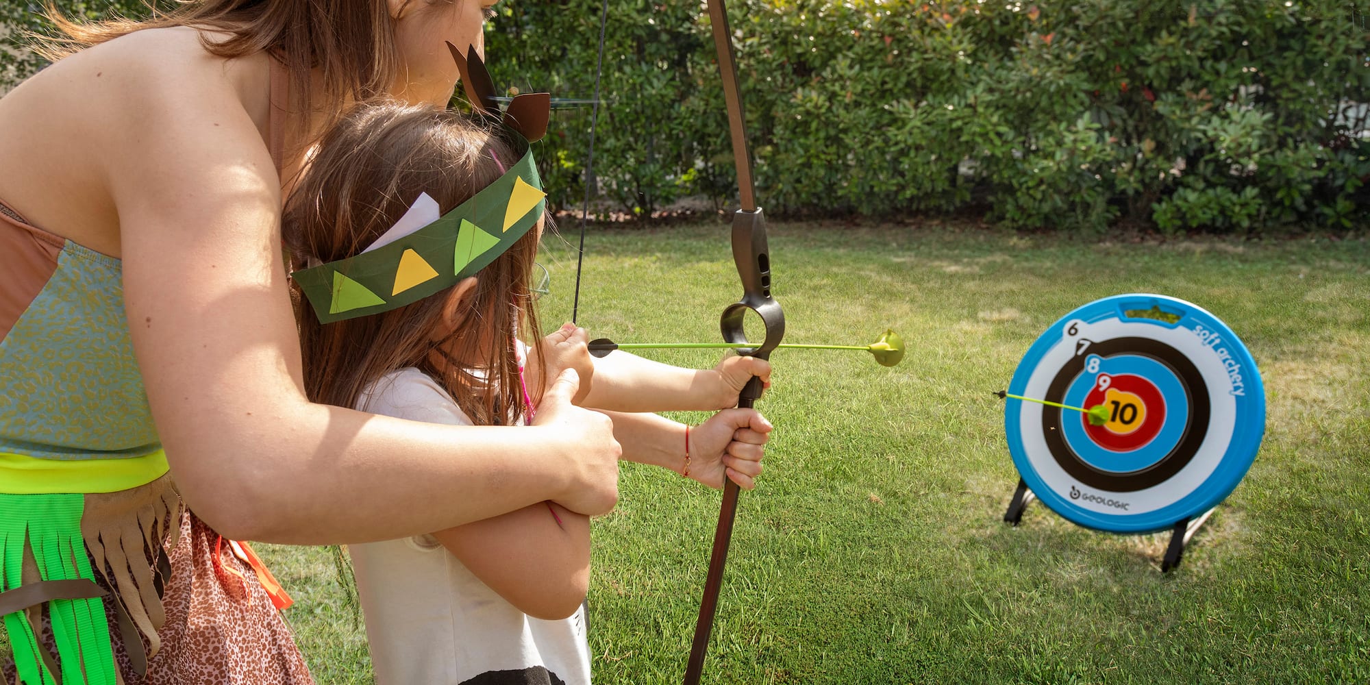 a woman and a girl shooting a bow and arrow