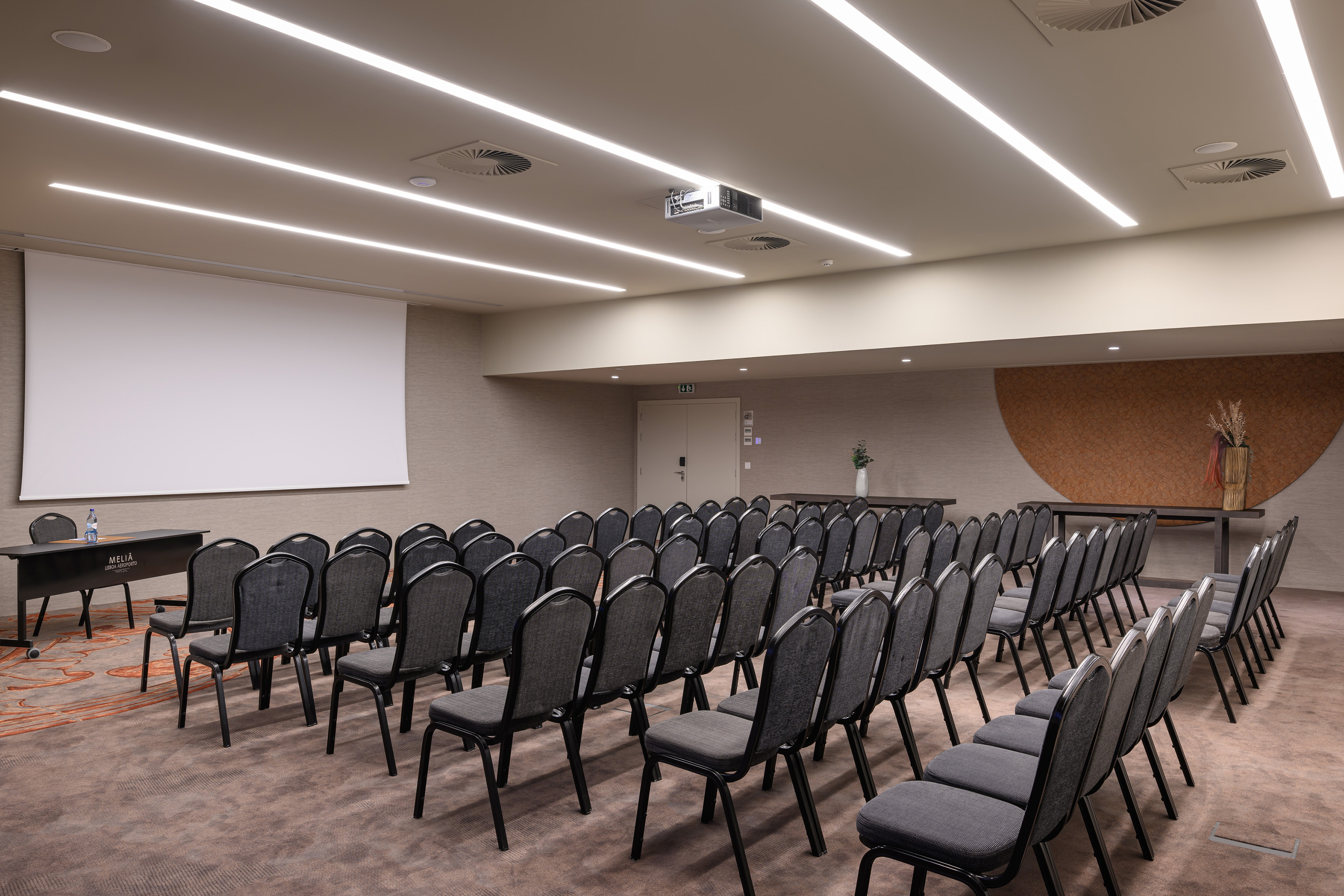 Meliá Lisboa Aeroporto meeting room, projector screen, rows of chairs.